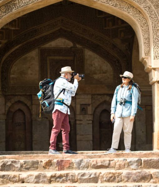 Senior man photographing wife using camera on vacation post retirement